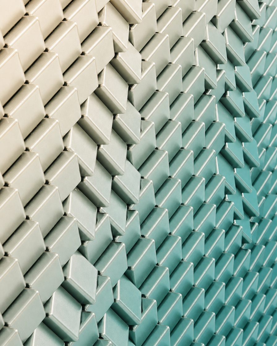 Close view of dimensional ceramic tile transitioning from off-white to light turquoise in a chevron pattern.