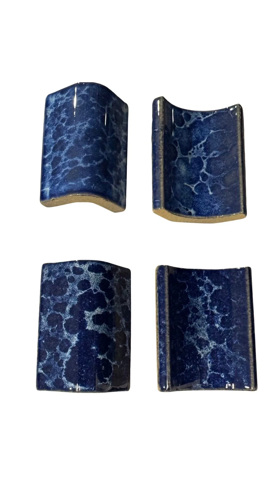 Curved blue glazed ceramic tiles for pool steps and edges.