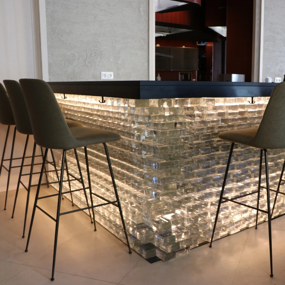 Completed bar counter built from illuminated glass blocks in a contemporary interior.