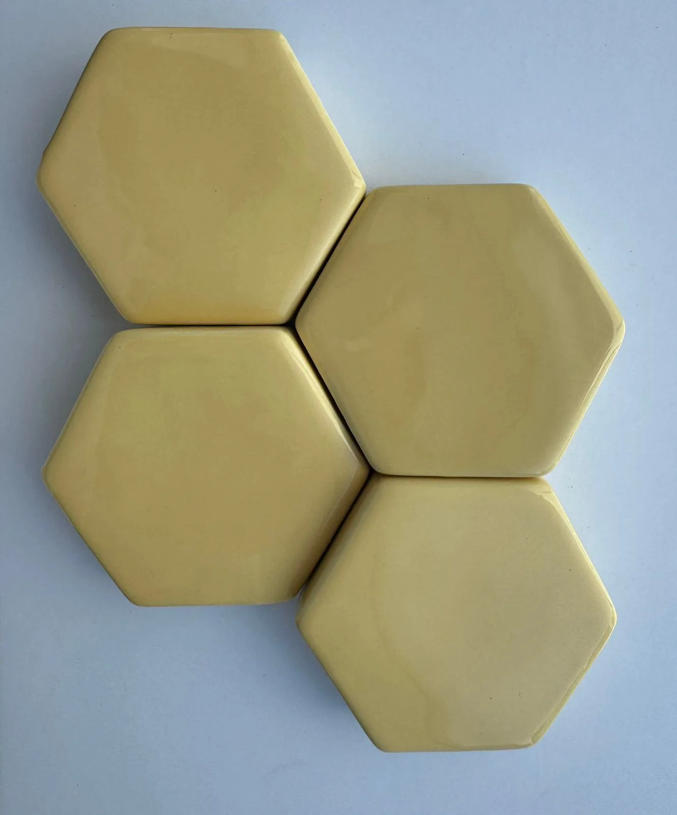 Pale yellow hexagonal glazed ceramic wall tiles.