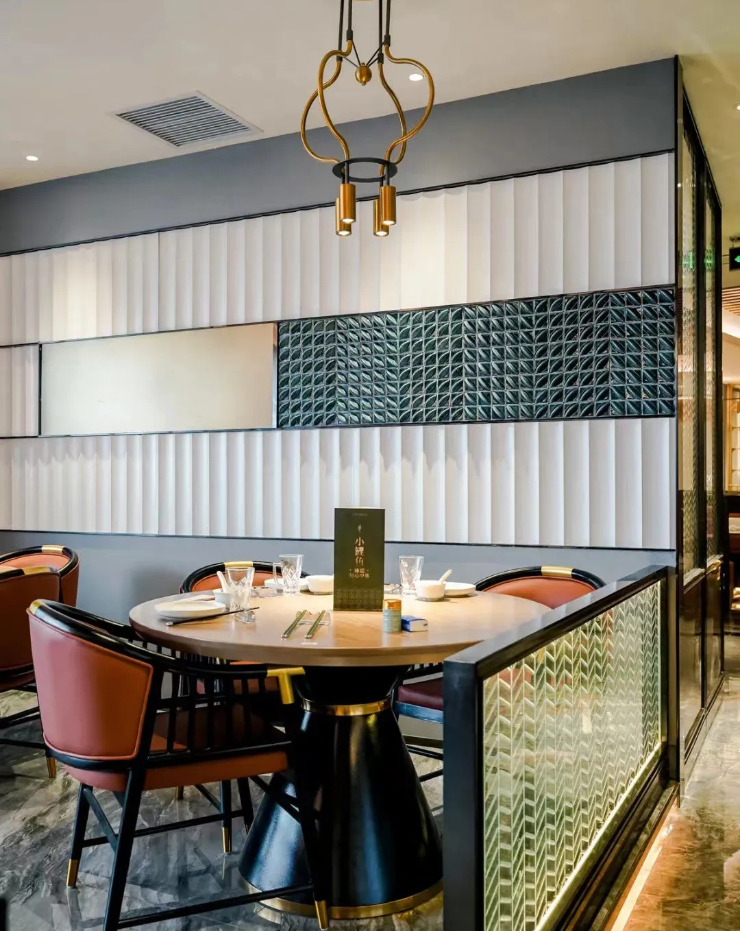Foshan Little Carp Restaurant interior with a sculptural glazed mosaic wall.