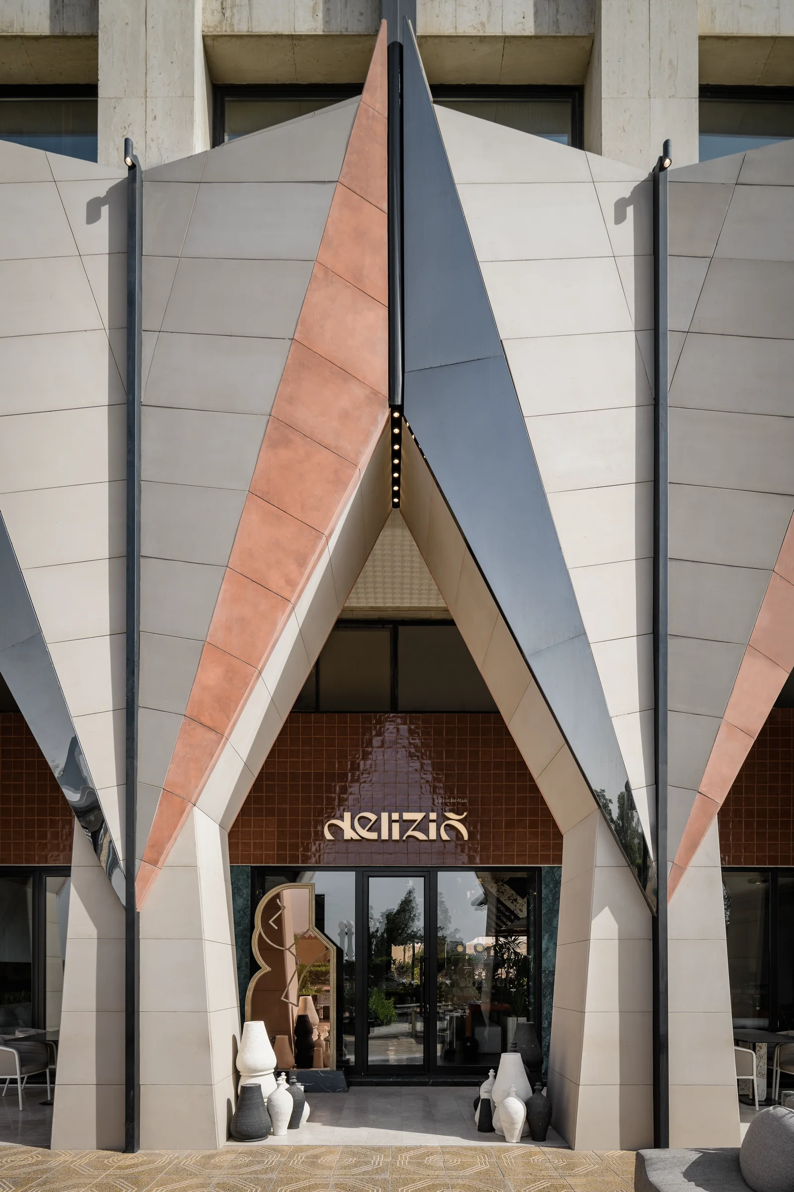 Delizio facade with geometric stone cladding and ceramic tile details.
