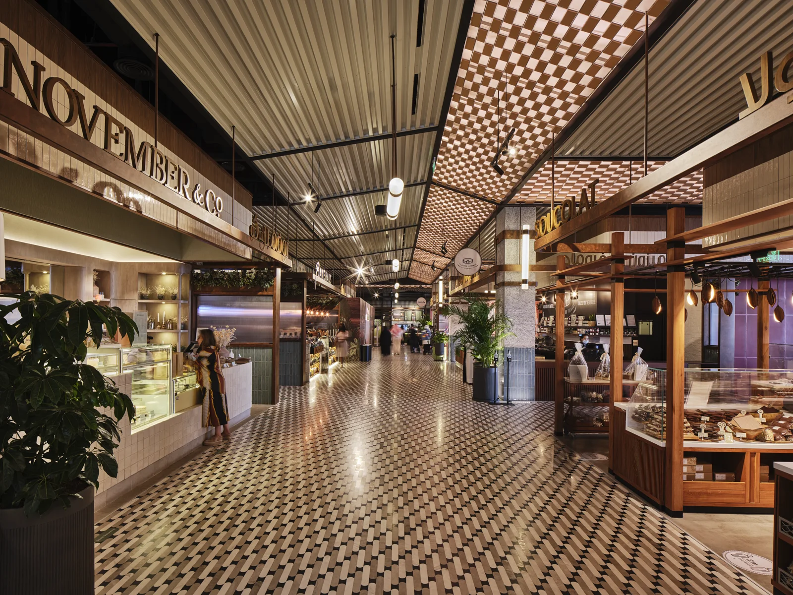 Architectural interior with tiled flooring, timber storefronts, and warm lighting.