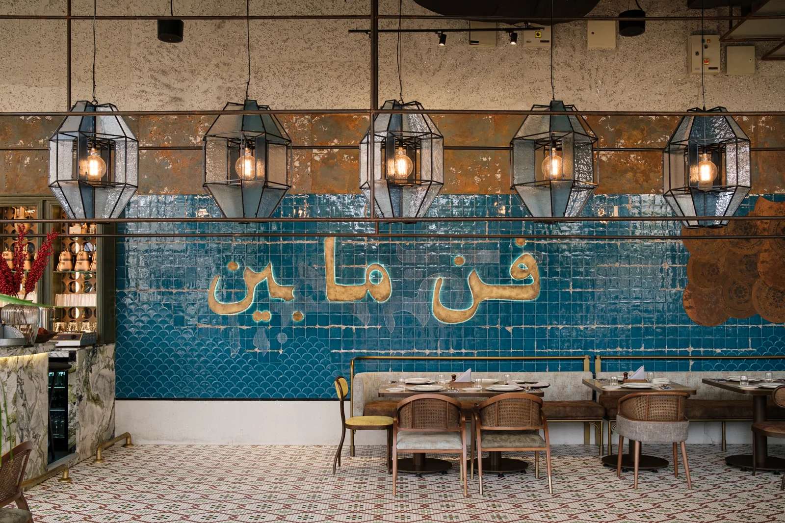 Restaurant interior with patterned ceramic surfaces and sculptural lighting.